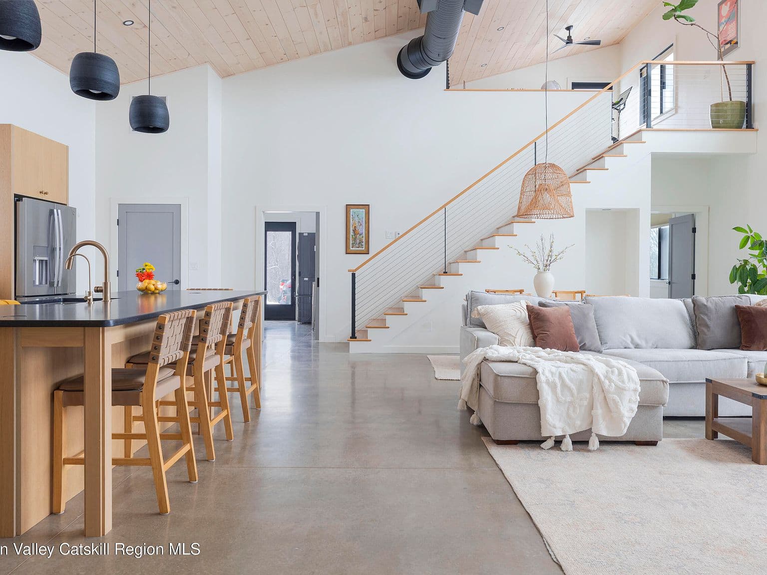 Living room with cathedral ceiling and staircase to the loft