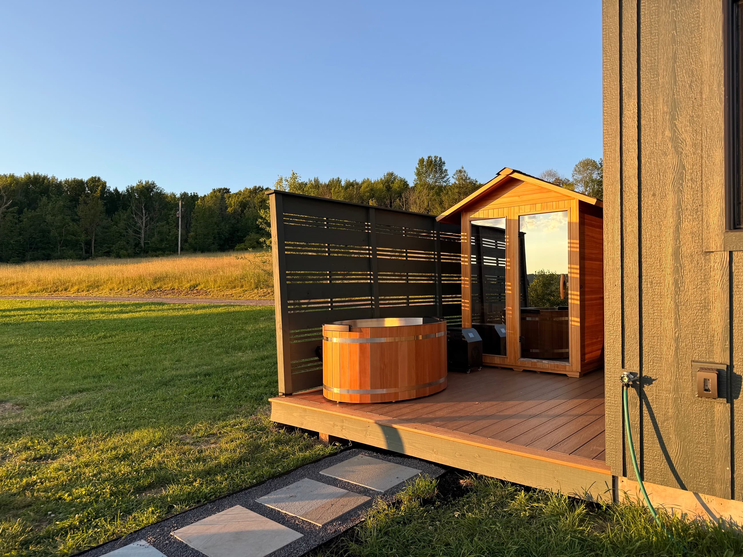 The sauna and cold plunge on the back deck in golden light