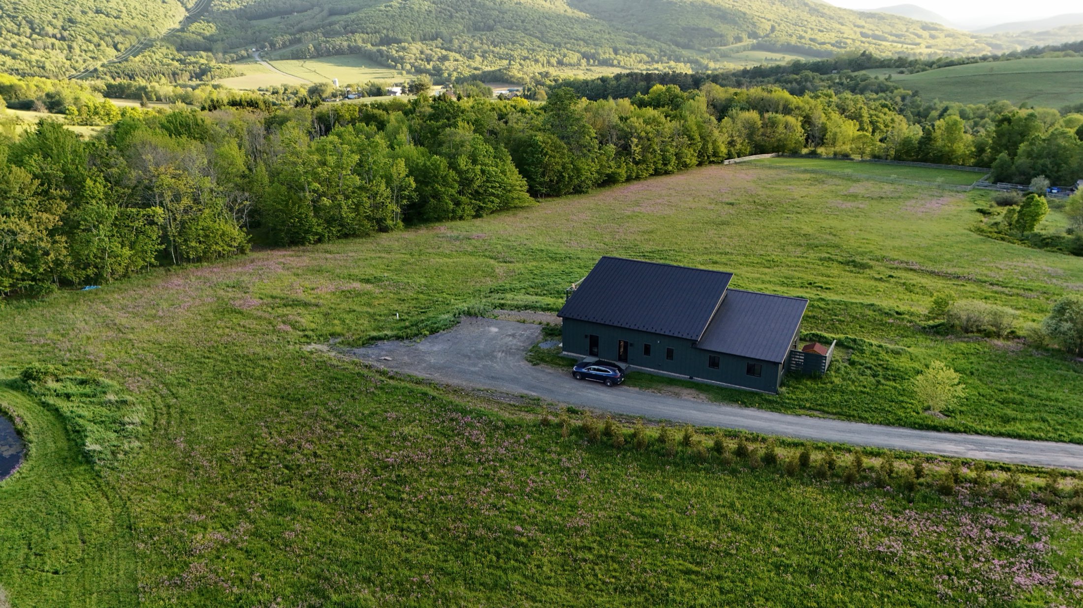 Aerial view of Decker House across the summer field and the Catskill ridge