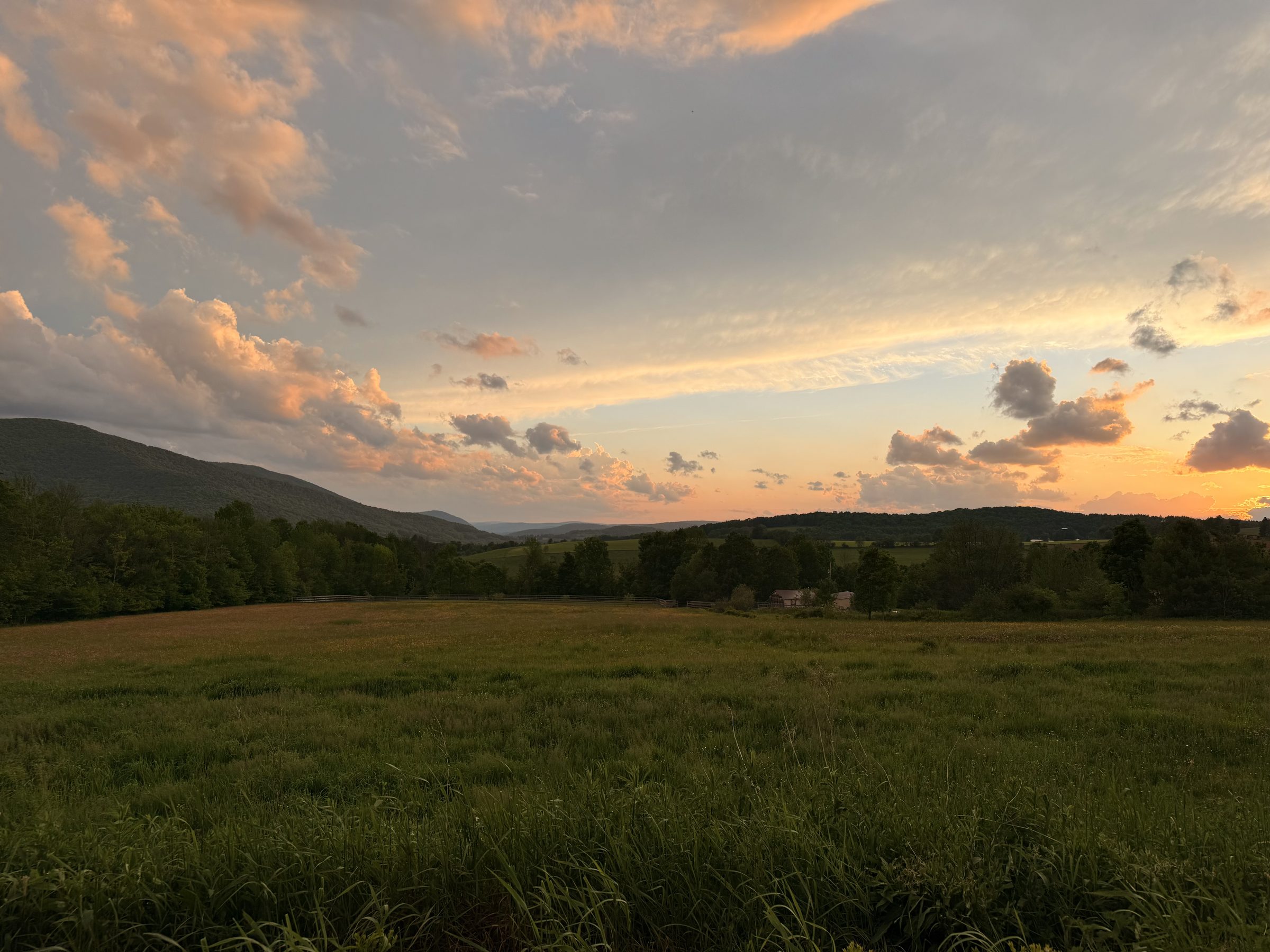 Sunset clouds over the field and the western ridge